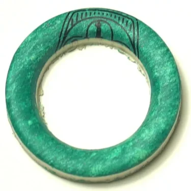 The SP.229 5 LITER ALIMENTARY RESISTANCE GASKET is a green foam ring with a worn, textured surface, a hollow center, and partial black print on the top side resembling an arch or dome. © 2025 1st-line.com