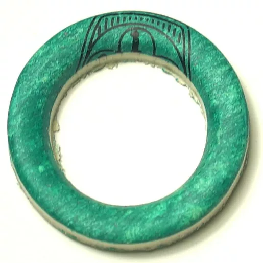 The SP.229 5 LITER ALIMENTARY RESISTANCE GASKET is a green foam ring with a worn, textured surface, a hollow center, and partial black print on the top side resembling an arch or dome. © 2025 1st-line.com