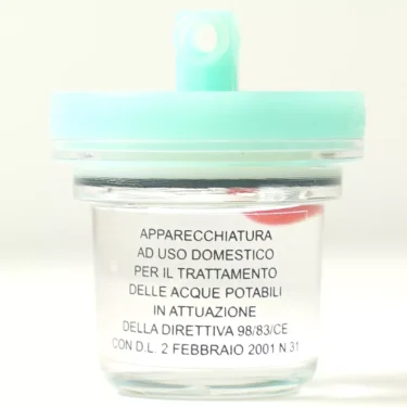 The V..995 PIPE 8mm 2000 LITER FILTER is a small transparent container with a light blue lid, labeled in Italian for domestic water treatment, fits PIPE 8mm, and meets European directives and legislation. © 2025 1st-line.com