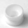 The V294 PTFE BUSHING 15x10.5mm is a small, white, round spacer with a hollow center, resembling a shallow cup and displayed on a plain white background. © 2025 1st-line.com