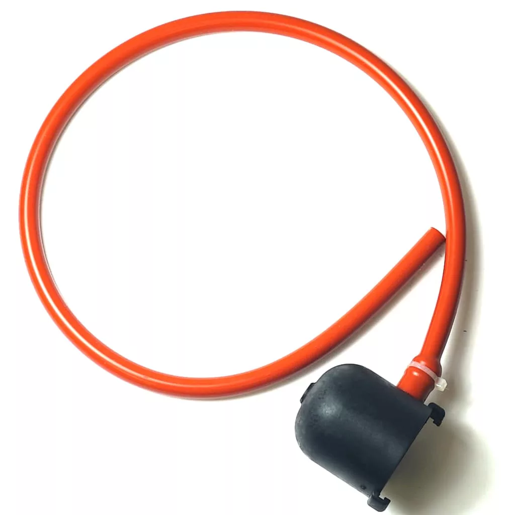 The ValveCover Safety Valve Protection Assembly features a bright orange rubber tube connected to a black plastic safety valve, shown against a white background. © 2025 1st-line.com