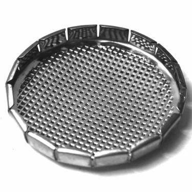 A black and white close-up highlights the G...63 SHOWERs round, metallic form with a textured, grid-patterned surface and raised, segmented edges, showcasing its precise detailing. © 2025 1st-line.com