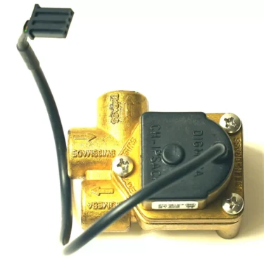 A brass solenoid valve with a black plastic cover and cable connector is shown from above on a white background, positioned next to an F.1904 DIGMESA FLOWMETER 3-WAY. © 2025 1st-line.com