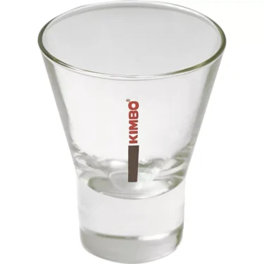 A clear, empty glass espresso shot glass with a thick base. KIMBO is printed vertically in red beside a brown stripe—ideal for dosing shots from your DISCONTINUED Mazzer SMISCAEU6/QQQ Short Bean Hopper Assembly (320g). © 2025 1st-line.com