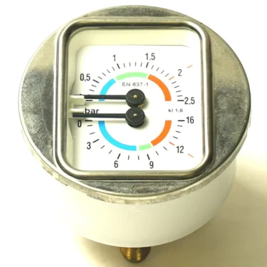 A close-up of a round pressure gauge with a square metal frame shows a 0–4 bar scale with blue, orange, and green segments; an F.2951 ELBOW 1 CUP SPOUT fitting is visible beside the gauge. © 2025 1st-line.com