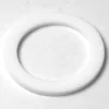 A close-up of a white, flat washer—used to seal connections in the F.1402 FAEMA E-91/DUE Stainless Steel Steam Wand—lying on a smooth, light-colored surface. © 2025 1st-line.com
