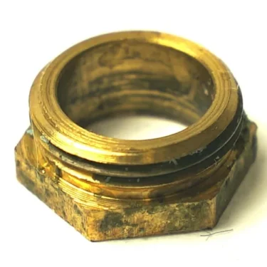 A close-up of the Ascaso I.2909 Hot Water Large Stem Holding Nut, showing its brass hexagonal form with internal threading and visible tarnish and wear. © 2025 1st-line.com