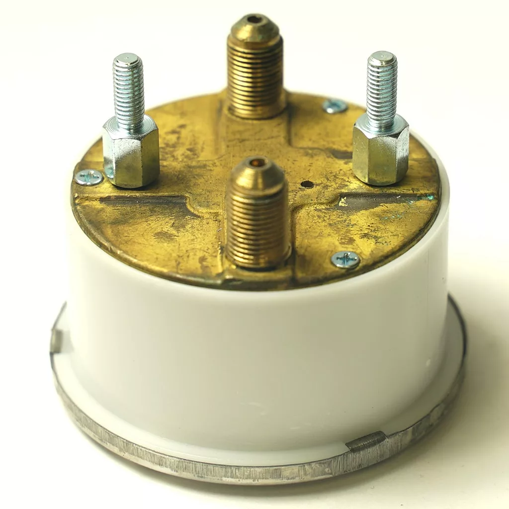 A close-up of the back of a round electrical component with a white body, brass top, and three metal terminals—showing details similar to the F.2951 ELBOW 1 CUP SPOUT. © 2025 1st-line.com