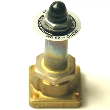 A close-up of the F.1863 PARKER SOLENOID VALVE BODY 128 SERIES featuring a square brass body with corner mounting holes, a round black push button, and a metal label marked “Parker Hannifin MODP 20 bar.”. © 2025 1st-line.com