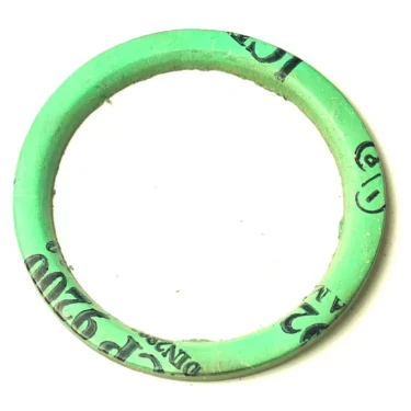 A Gaggia PTFE Heating Element Gasket (50x40x2mm), circular and green, featuring partially visible black text on its surface, is shown against a white background. © 2025 1st-line.com