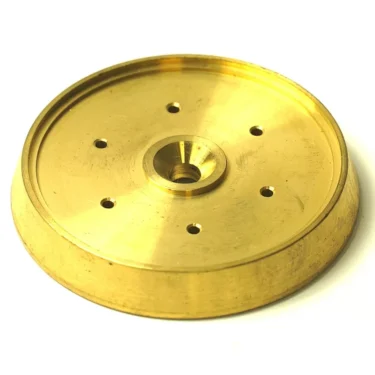 A gold-colored, round metal disk with a raised edge, center hole, and six evenly spaced smaller holes—ideal as the F.1026 FAEMA SUPER STAR SPRAY component. © 2025 1st-line.com