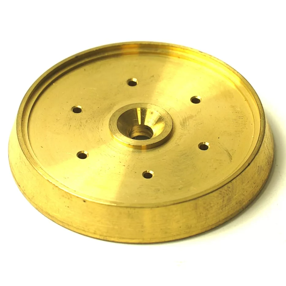 A gold-colored, round metal disk with a raised edge, center hole, and six evenly spaced smaller holes—ideal as the F.1026 FAEMA SUPER STAR SPRAY component. © 2025 1st-line.com