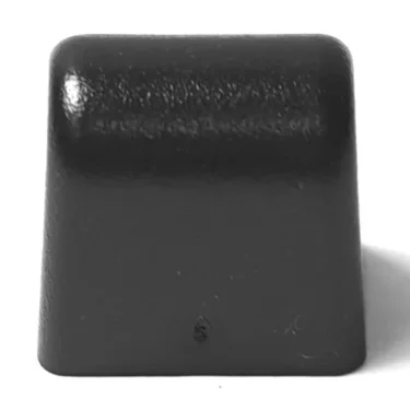A single black F.1182 FAEMA/E-61 Group to Boiler Alimentary Gasket with a slightly textured surface, shown from the front against a white background—similar in shape to a keyboard keycap. © 2025 1st-line.com