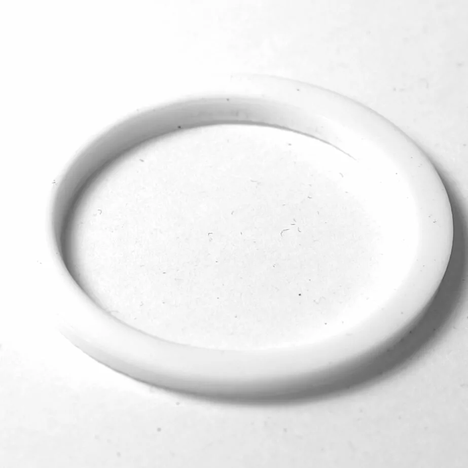A white, circular plastic ring from the F.2451 PULSER FILTER KIT rests flat on a plain, light surface, with a soft shadow in the background. © 2025 1st-line.com