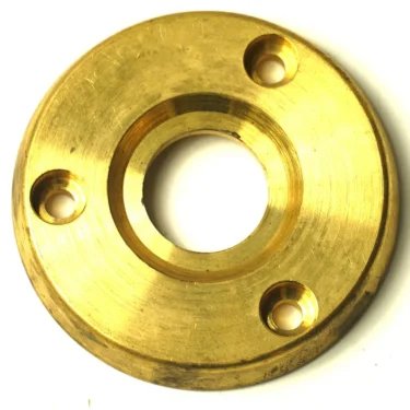The F.1808 STEAM/WATER HANDLE RUBBER PROTECTOR is a round, flat brass flange with a central hole and three evenly spaced smaller holes, featuring a polished golden surface for mounting cylindrical objects like water handles. © 2025 1st-line.com