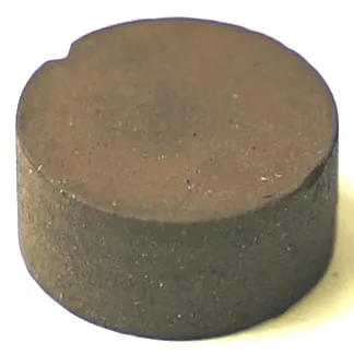 The F..326 CLOSING TAP GASKET 12x5.8 mm is a round, solid brownish metal disk with a small edge notch, shown on a plain white background. © 2025 1st-line.com