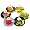 The Francis!Francis! Ice Cellars Collector Gift Set features six vibrant espresso cups with matching saucers, each adorned with floral or abstract designs and arranged upside down in a circular pattern. © 2025 1st-line.com