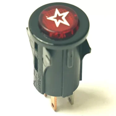 The HIT.85 MOMENTARY PUSH SWITCH features a red illuminated button with a white star symbol, housed in a black cylindrical plastic casing with two metal prongs for connections. © 2025 1st-line.com