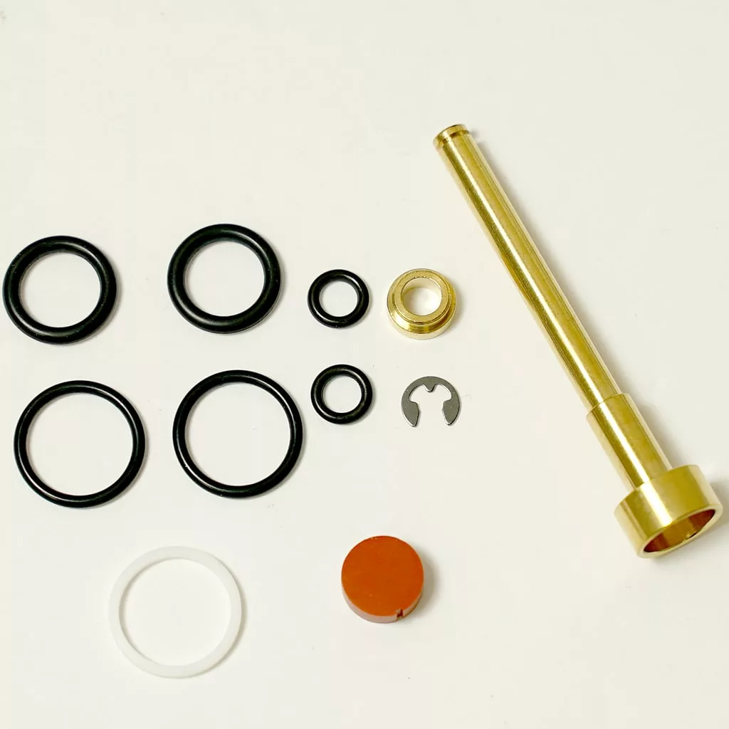 The image shows the DISCONTINUED Lelit 4000030 Steam Valve Shaft and assorted parts including black O-rings, a brass ring, a white ring, a metal clip, and an orange disc on a white background. © 2025 1st-line.com