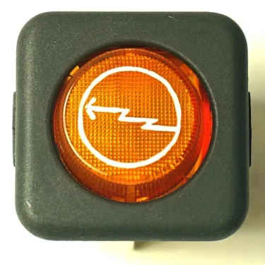The LAV146 WARNING LAMP 230V is a square black plastic button with an orange circular center and a white left-pointing zigzag arrow, used as a dashboard indicator or control. © 2025 1st-line.com