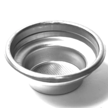 The MZ.270 7GR ORIGINAL 1-CUP FILTER, a metal portafilter basket with a perforated bottom, is shown on a white surface from an angled view that displays both its side and interior. © 2025 1st-line.com