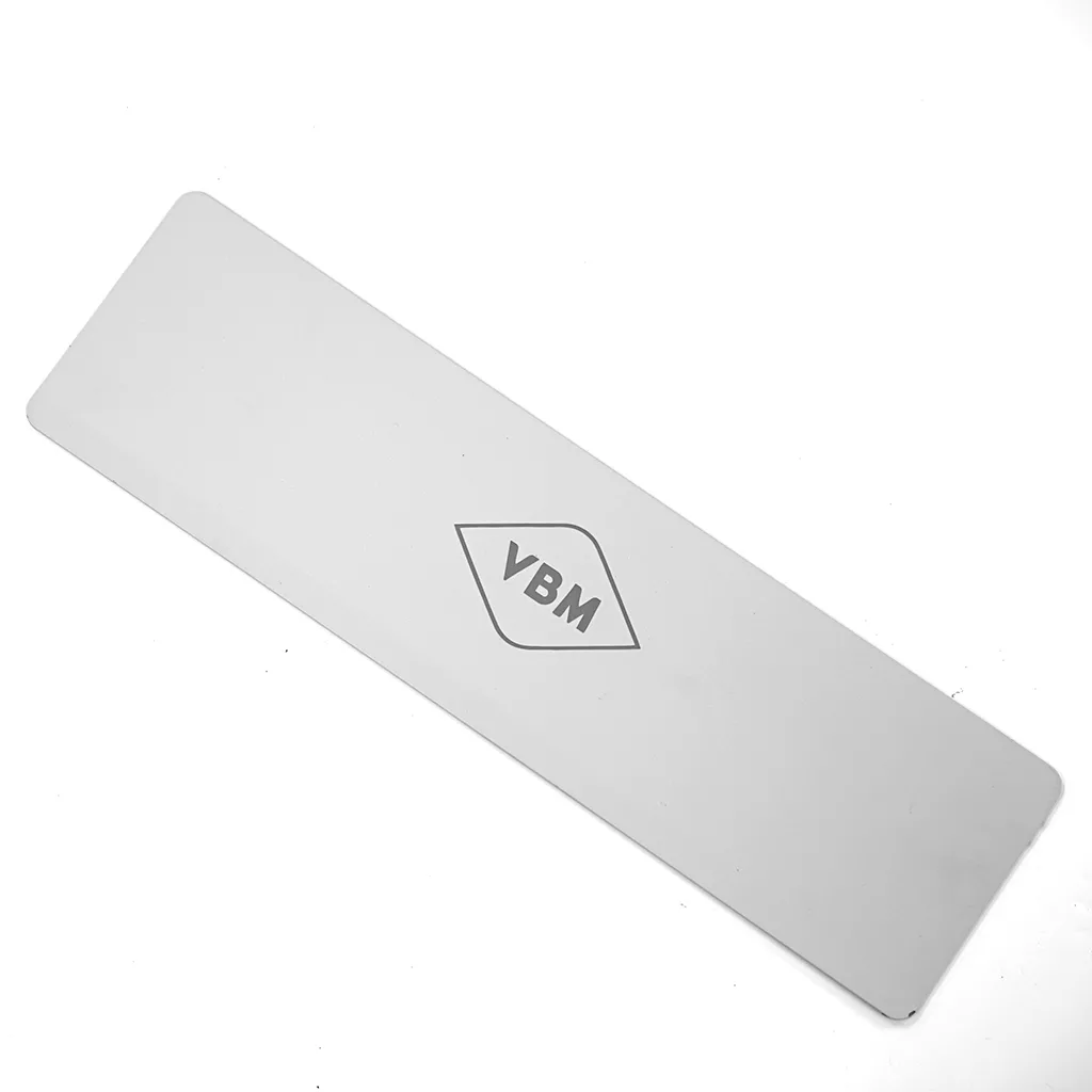 The VBM CARRCASPPDSV COMPLETE features a rectangular silver metal panel with rounded corners and a VBM logo in a diamond outline at the center, shown on a white background next to its complete white drip tray. © 2025 1st-line.com