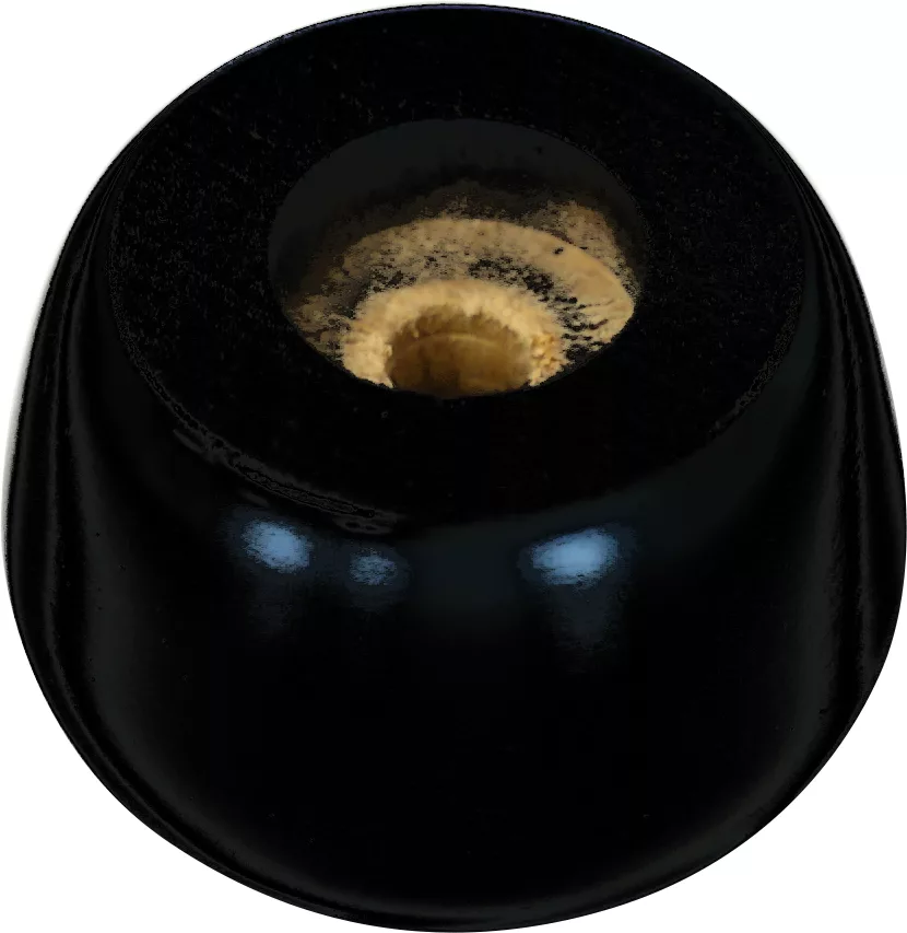 A close-up of a black licorice candy with a beige, chewy center on a white background—its sleek finish reminiscent of the Lelit 4100011 Black Wood Foot. © 2025 1st-line.com