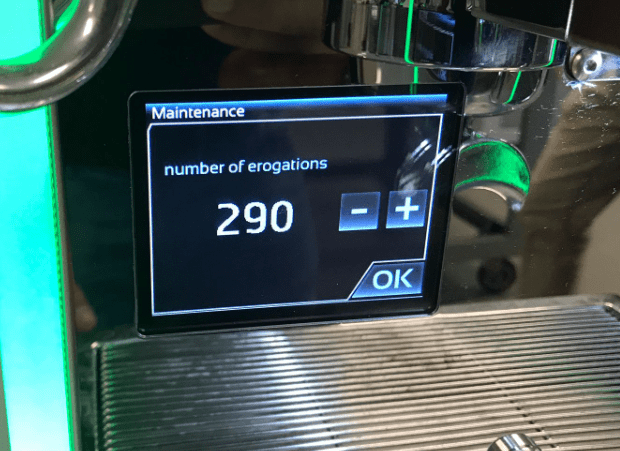 A Bezzera Duo coffee machine display shows Maintenance and erogations: 290, with minus, plus, and OK buttons. The metal drip tray is visible below the screen—a classic look for Bezzera Matrix owners experiencing timer issues. © 2025 1st-line.com