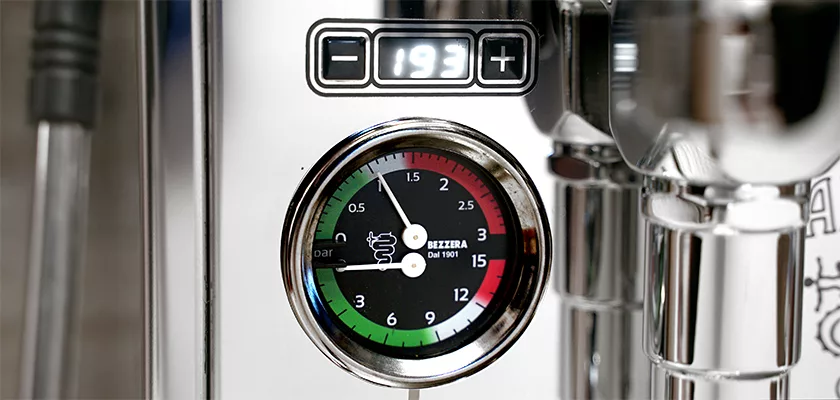 A close-up of the Bezzera Aria HX Special Edition Espresso Machine w/ Flow Control shows its pressure gauge with colored sections, a needle, and a digital temperature display reading 193°F above the reflective chrome surface. © 2025 1st-line.com