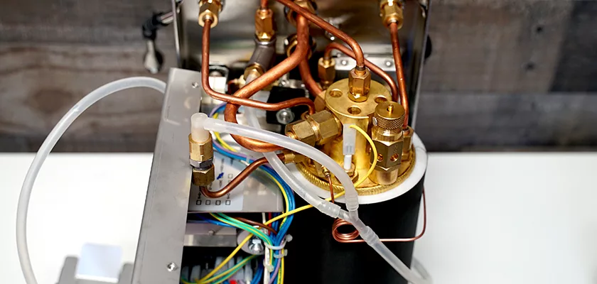 Close-up of the Bezzera Aria HX Special Edition Espresso Machine w/ Flow Control, highlighting internal copper pipes, brass fittings, electrical wiring, and the cylindrical boiler with flow control mechanisms. © 2025 1st-line.com