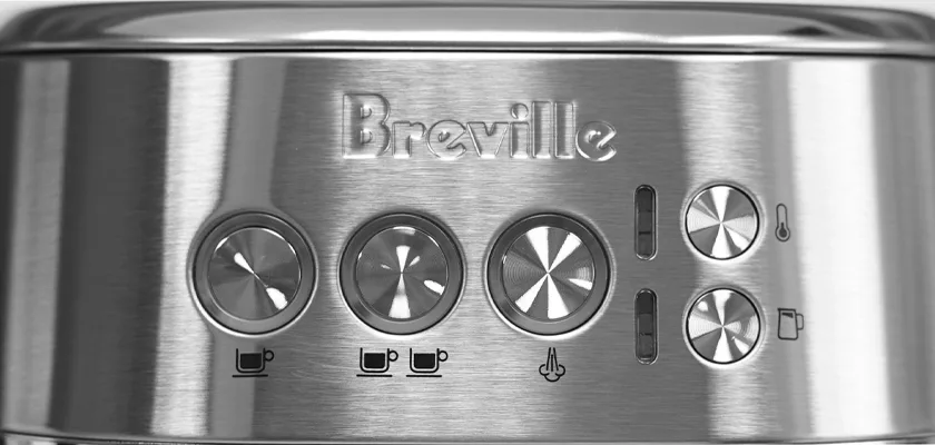 Close-up of the Breville Bambino Plus™ Espresso Machine’s stainless steel control panel with four round buttons for single/double espresso, hot water, and steam, plus two vertical indicator lights. © 2025 1st-line.com