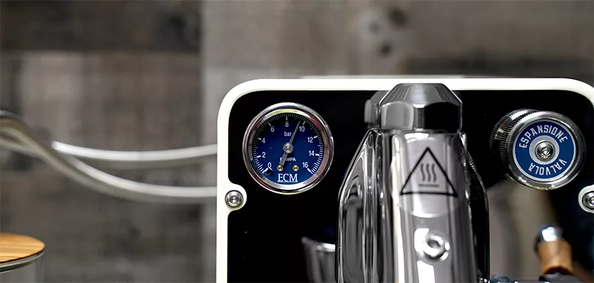Close-up of the DISCONTINUED ECM Puristika Espresso Machines pressure gauge with a metallic finish and blue dial. The modern design showcases visible knobs and control details in a sleek build. © 2025 1st-line.com