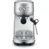 The Breville Bambino™ Espresso Machine in silver, featuring a steam wand, drip tray, control buttons, and portafilter holder, is shown from the front against a white background. © 2025 1st-line.com
