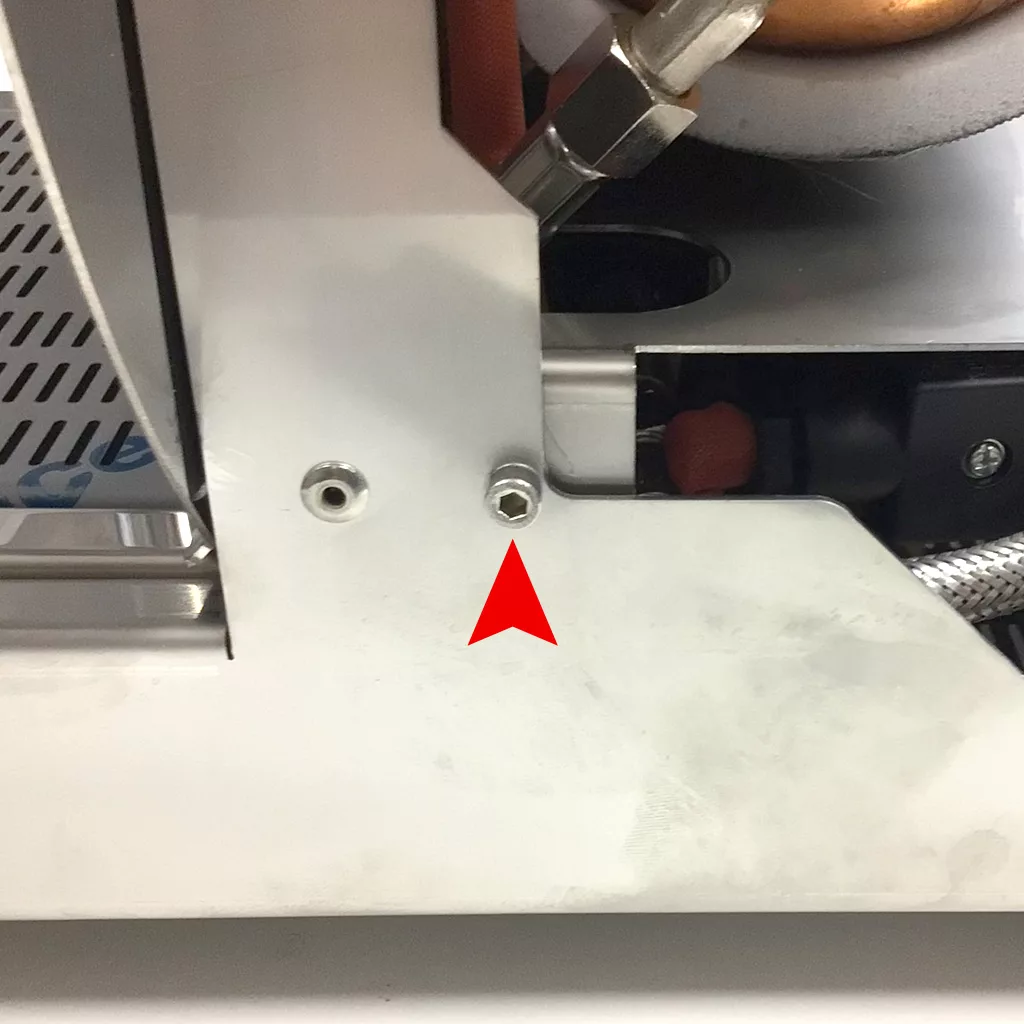 A red arrow points to a hexagonal bolt on a metallic Cuadra machine surface, indicating the part for accessing the inside. © 2025 1st-line.com
