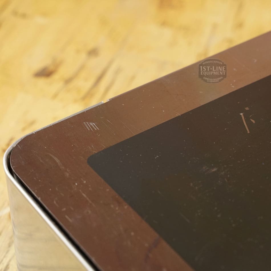 Close-up of a SIDEWALK SALE - Lelit PLA360M Knock Box Drawer (E208) with visible scratches near the corner of its black glass panel, shown on a light wooden background. © 2025 1st-line.com
