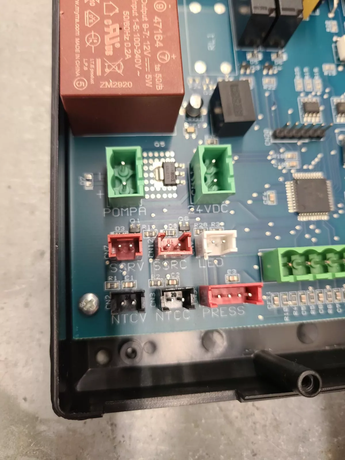 Close-up of an electronic circuit board with labeled connectors like POMPA, 24VDC, SRV, SRC, and others. The Brain Units manage green, red, black, and white connectors with visible components such as relays and pins. © 2025 1st-line.com