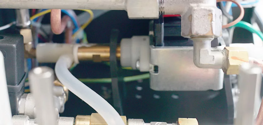 Close-up of metal pipes, valves, wiring, and tubing inside the Rocket Appartamento TCA HX Espresso Machine highlights the TCA HX system and its intricate industrial design. © 2025 1st-line.com