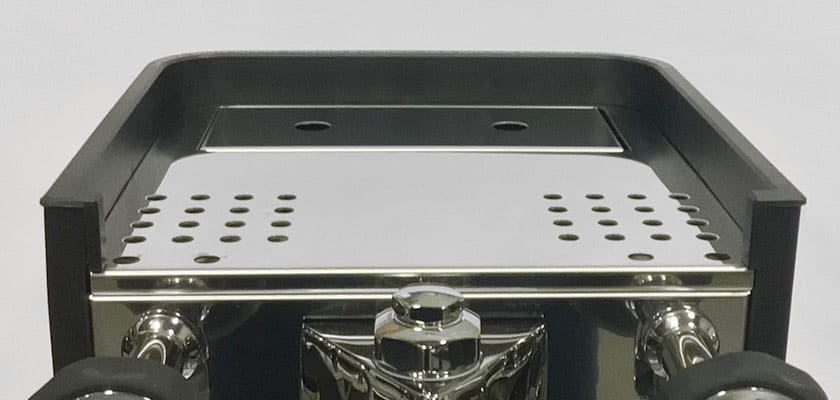 Close-up of the Rocket Appartamento TCA HX Espresso Machines top, showcasing a sleek metallic finish, black-edged drip tray with round drainage holes, set against a plain background. © 2025 1st-line.com