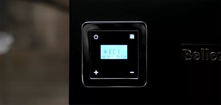 A close-up of the Bellezza Bellona Dual Boiler Espresso Machine shows its control panel with “EC1” and temperature on the screen, plus power and settings buttons on its glossy black surface. © 2025 1st-line.com