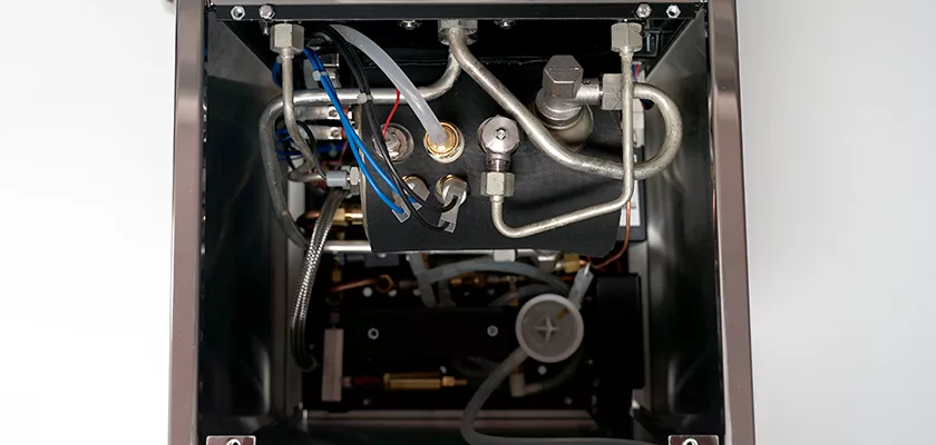 A top-down view of the Rocket Giotto Cronometro Type V HX Espresso Machine reveals neatly organized metal pipes, wires, and fittings housed within its robust metallic frame. © 2025 1st-line.com