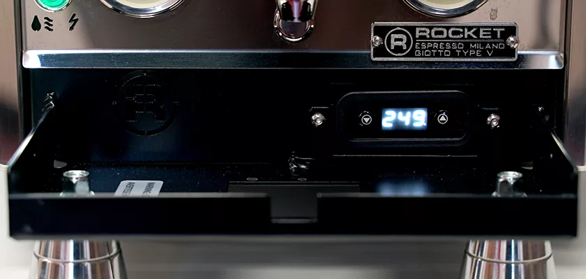 Close-up of the Rocket Giotto Cronometro Type V HX Espresso Machine, featuring a digital display reading 24.9, labeled buttons, metallic surfaces, and part of the drip tray visible below. © 2025 1st-line.com