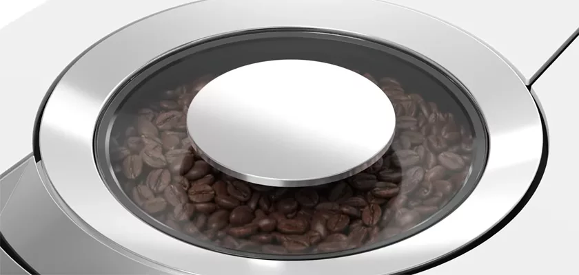 A close-up shows coffee beans inside a round compartment with a transparent lid on the sleek Jura Z10 Super-Automatic Espresso Machine. © 2025 1st-line.com