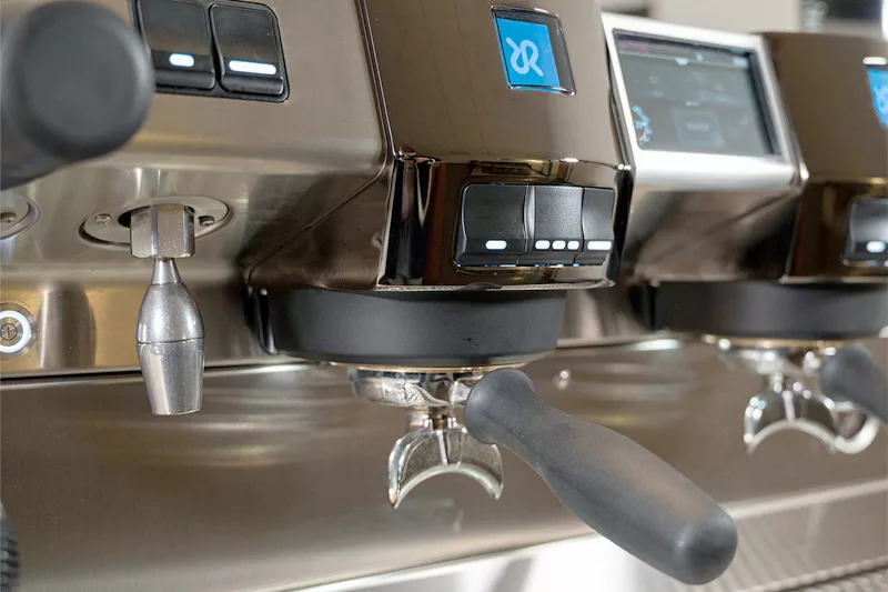 Close-up of the Rancilio Invicta 2 Group Commercial Espresso Machine, featuring metal portafilter handles, control buttons, steam wand, and digital displays on a sleek stainless steel surface. © 2025 1st-line.com