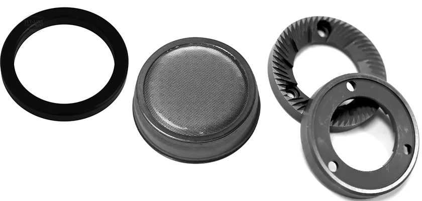 Four metal coffee grinder parts shown on a white background, including a black ring, metal mesh filter, serrated burr, and matching circular grinder component with holes—ideal for espresso equipment maintenance and care. © 2025 1st-line.com