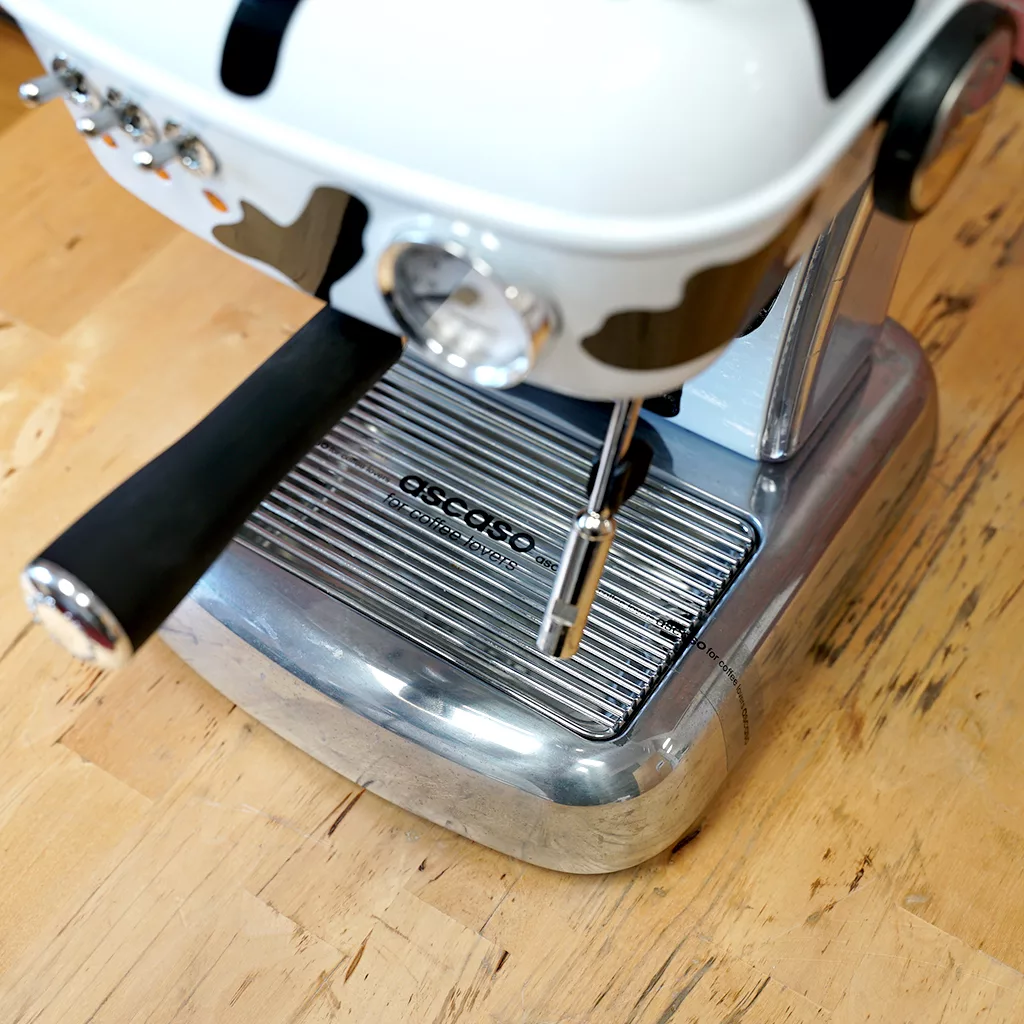 Close-up of the SIDEWALK SALE - Ascaso Dream (Cow) UP V2 Espresso Machine (E011) on a wooden countertop, showing its steam wand, drip tray, and portafilter—an ideal choice for coffee lovers at our Sidewalk Sale. © 2025 1st-line.com