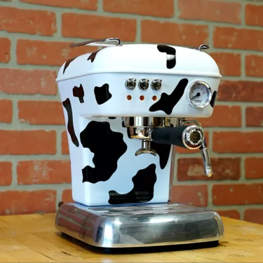 The SIDEWALK SALE - Ascaso Dream (Cow) UP V2 Espresso Machine (E011) features a chic cow print design—ideal for making a statement at your sidewalk sale display. © 2025 1st-line.com
