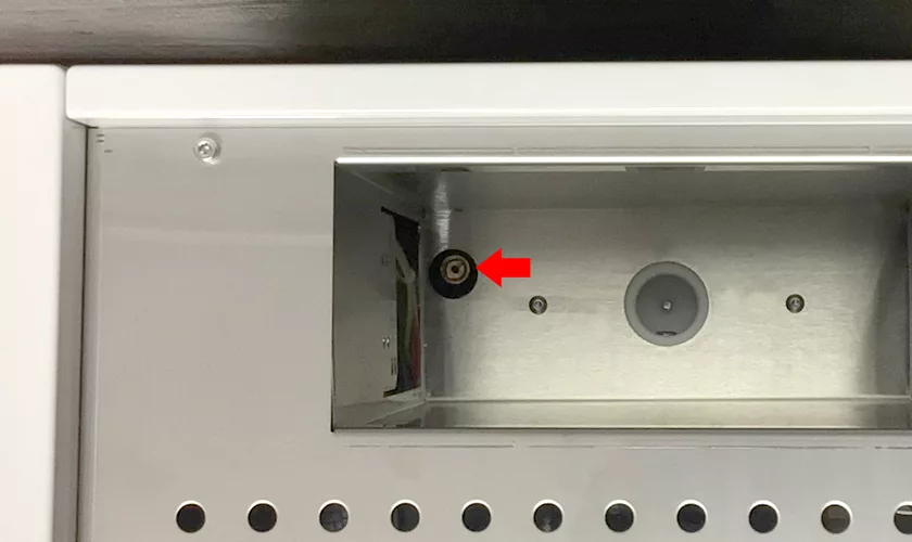 A close-up of a metallic compartment in the Torre Peppina EVO Premium V1 Dual Boiler Espresso Machine w/ FC shows a red arrow highlighting a small black circular connector beside a gray circular feature on the right side. © 2025 1st-line.com