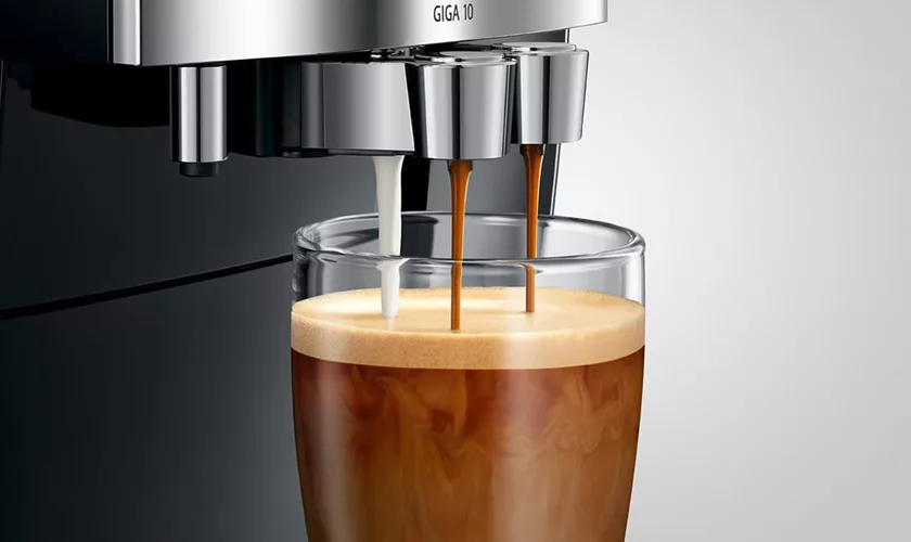 A Jura GIGA 10 Super-Automatic Espresso Machine prepares a glass of freshly brewed espresso. © 2025 1st-line.com