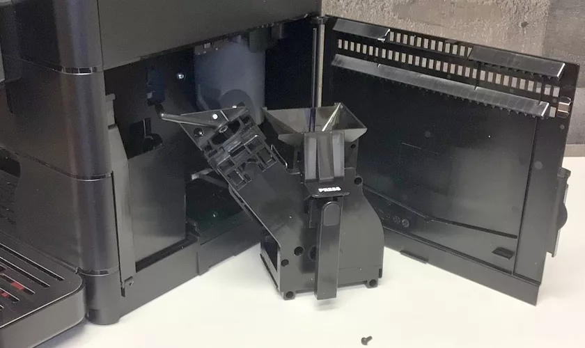 A close-up of the discontinued Saeco New Royal OTC Super-Automatic Espresso Machine with its front panel open, showing internal brew group and gears. The removed brew unit sits on a white surface in front of the machine. © 2025 1st-line.com