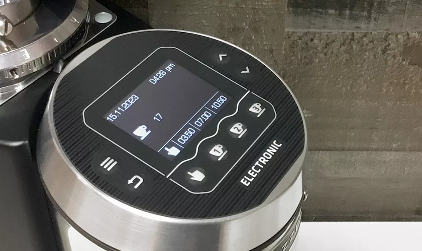 Close-up of the Mazzer Super Jolly V Pro Espresso Coffee Grinder’s digital display with date, time, cup icon, number 17, and various settings. The control panel includes buttons for effortless navigation and selection. © 2025 1st-line.com